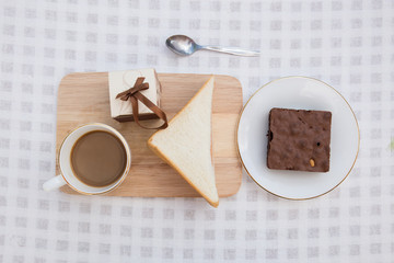 A cup of coffee with brownie cake and sandwich