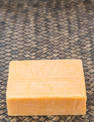 A block of cheddar cheese over wicker background