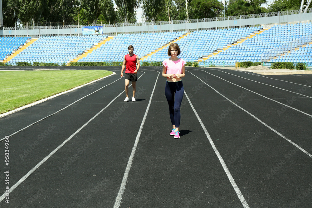 Wall mural young people jogging on stadium