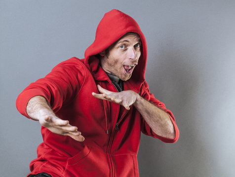 male adolescence concept - dancing middle age wearing a red hooded sweater playing rapper with fun hand gesture,studio