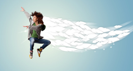 Healthy young woman jumping with feathers around her