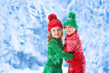 Kids playing in snowy winter forest