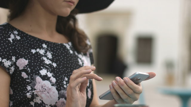 Closeup of female hands typing message, writing e-mail, chatting on smartphone