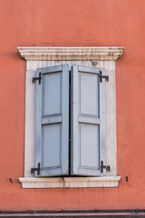 Fenster mit hellblauen Fensterläden, rote Wand