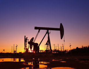 Oil field scene, the evening of beam pumping unit in silhouette