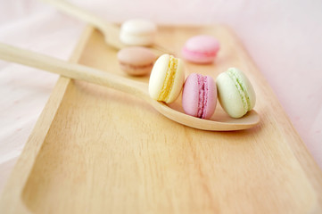 Colorful macaroons on the wooden spoon.