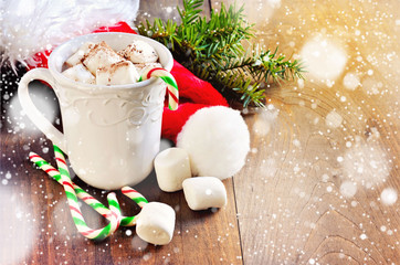 Cup of hot chocolate with marshmallows and candy, Christmas decoration, falling snow effect, toned image