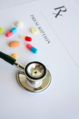 Pills and stethoscope on a prescription