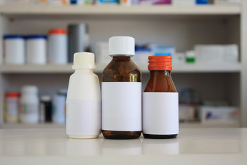 Blank white label of medicine bottle with blur shelves of drug i