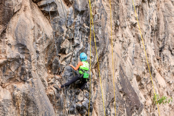 Hispanic Girl Climbing A Rock Wall