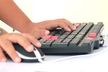 Human hand on computer mouse and keyboard on desk