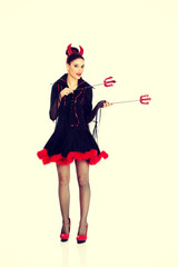 Devil woman pointing aside with trident. 