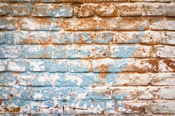Vintage faded brick wall in orange and blue colors, trendy urban wall background