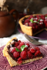 Piece of tart with fresh raspberries, on wooden background