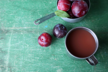 Delicious plum juice with fruits on wooden table close up