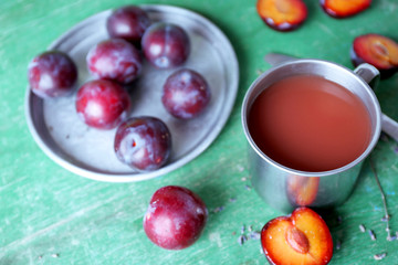 Delicious plum juice with fruits on wooden table close up