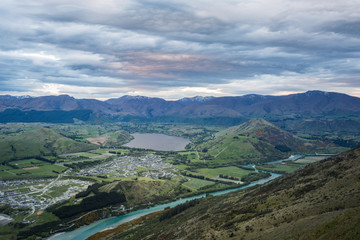 Naklejka premium river, mountain and dramtic clouds at sunset