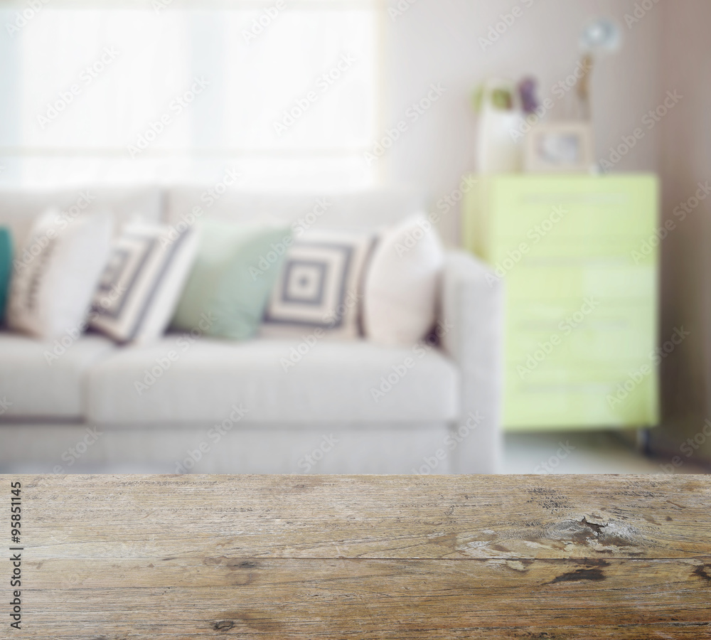 Wall mural wooden table top with blur of geometric pattern pillows on cozy