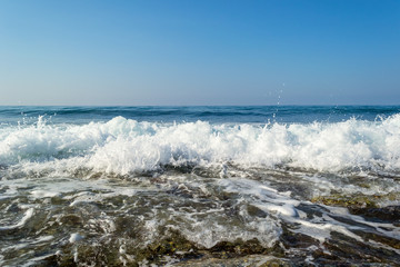 Waves breaking on a stony beach, forming sprays