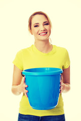 Young woman holding blue bucket.