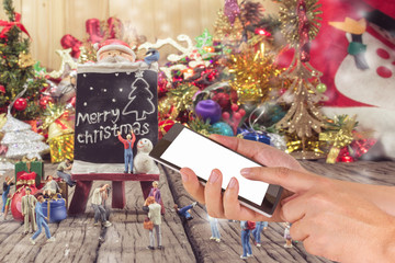 Naklejka na ściany i meble image of male hand using phone and Christmas ornaments