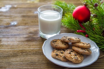 Cookies and milk for Santa Clause on wood background