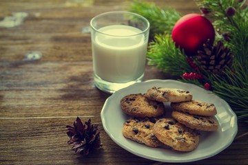 Cookies and milk for Santa Clause on wood background