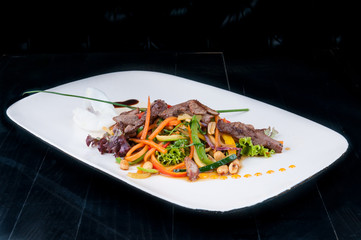 Chopped meat with vegetables served on a white plate. The meal is ready for eating