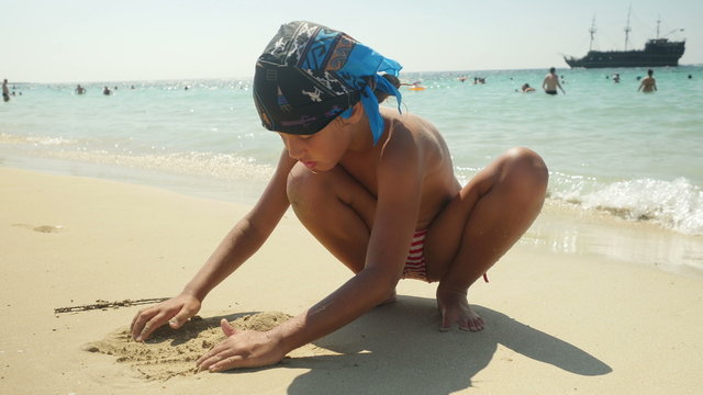 Child playing sand on the beach. 4K UHD.
