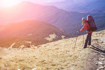 A girl stands on a beautiful mountain.