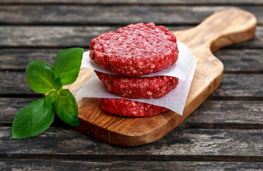 Home HandMade Minced Beef burgers on cutting board. old wooden table