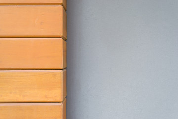 Gray cement wall with teak wood.