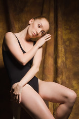 Fototapeta na wymiar Modern ballet dancer posing in dark interior