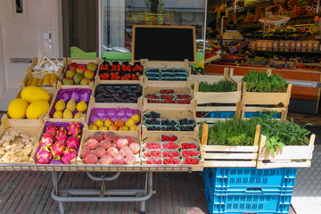 Shelf with fresh fruits and herbs in greengrocery store in Zandv
