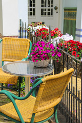 Small table and two chairs on a  fenced terrace near the buildin