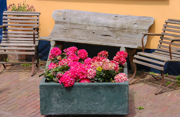 Traditional street decoration with flowers and wooden chairs in