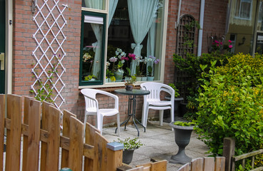 Street view of traditional house decorated with plants and furni
