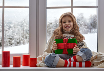 little girl sitting by the window