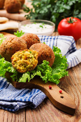 Chickpea falafel balls on a wooden desk with vegetables