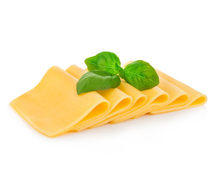 Slices of cheese with fresh basil leaves close-up isolated on a white background.