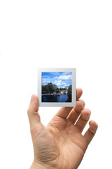 Male hand holding a framed piece of slide film isolated on white