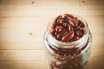 red  beans on wood background - soft focus with vintage film fil