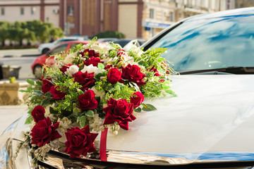 Wedding bouquet on the hood of the white car