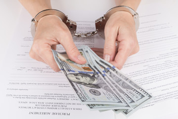 Weibliche Hände in Handschellen halten Dollar