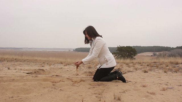 photographer takes pictures as a woman pours sand on the nature autumn