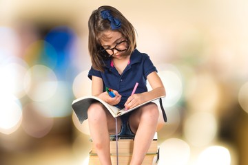 Girl studying on a pile of books