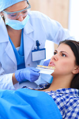 Woman dentist working at her patients teeth