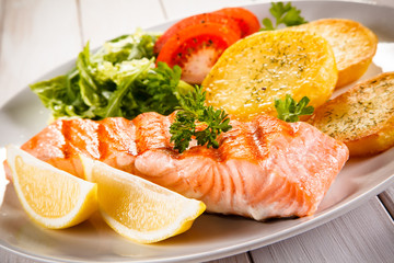 Fried salmon and vegetables on white background