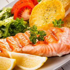 Fried salmon and vegetables on white background