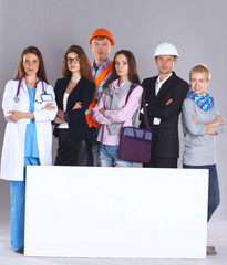 Portrait of smiling people with various occupations holding blank billboard
